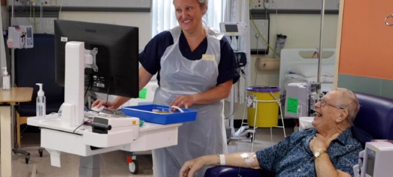 A nurse and a patient sharing a laugh during treatment